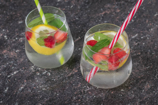 istock Two glasses of cold water with berries, lemon and mint. 1254705275