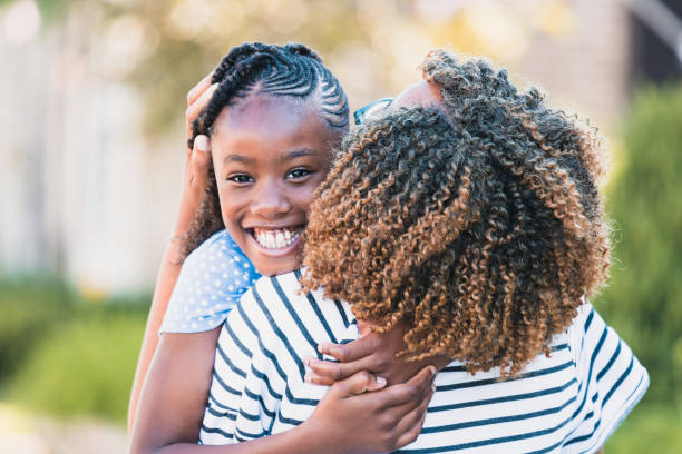 istock Big grin on daughter's face during hug from mom 1254705305
