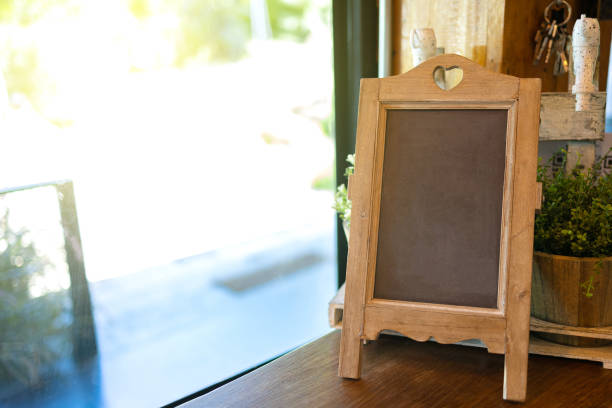 istock Blank vintage blackboard sign on wooden table by the window, Copy space for adding your content. 1254706345