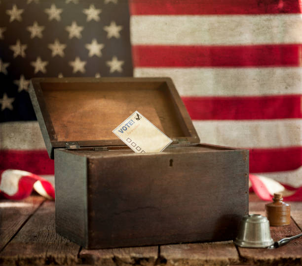 istock Ballot Box and an American Flag on Black Background 1254706430
