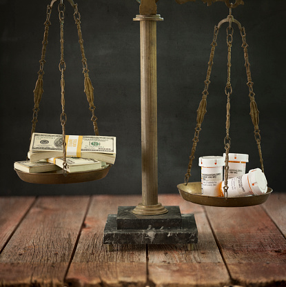 Hydroxychloroquine versus a stack of money representing more expensive drugs and big Pharma.