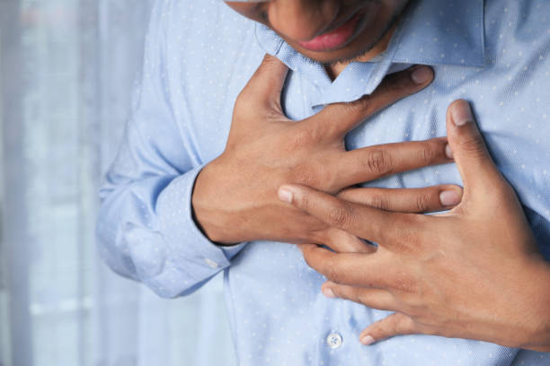 istock young man suffering heart and holding his chest 1254709201