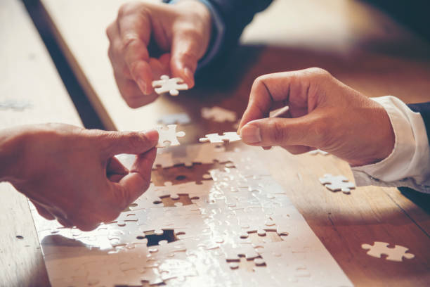 istock Unified synergy assembly business game implementation multiple puzzle meeting. Business connections strategy synergy team solution. Piece of jigsaw assembly by implement multiple game puzzle. Hands of unify team connect group of business people solutions 1254709268