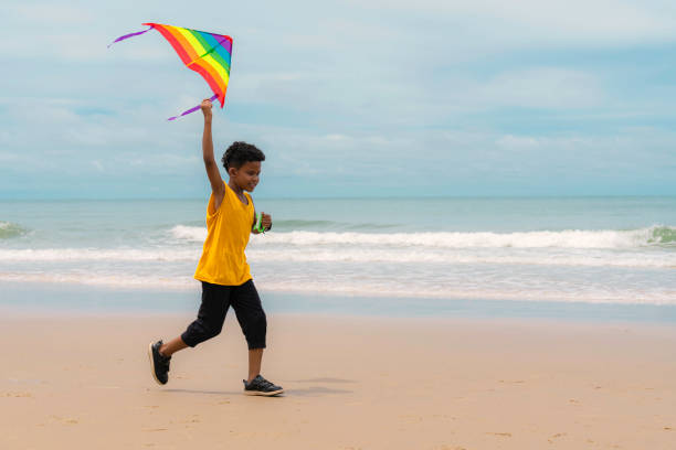 istock African American mixed race boy run on beach with rainbow kite 1254710207