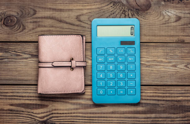 istock Calculator with leather wallet on wooden table. Shopping Cost Calculation 1254710350