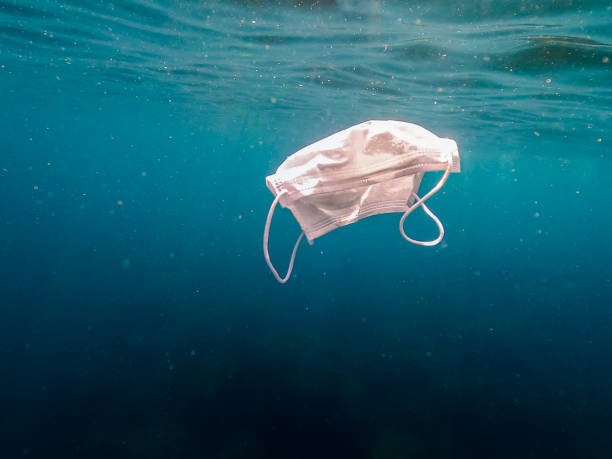 istock People throws out a medical face mask floating underwater on ocean water 1254710473
