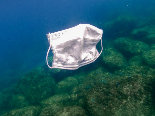 istock People throws out a medical face mask floating underwater on ocean water 1254710523