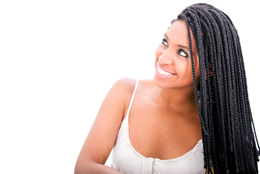Beautiful black woman with dreadlocks looking up smiling and daydreaming