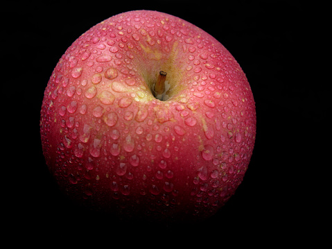 close up of red apple against black