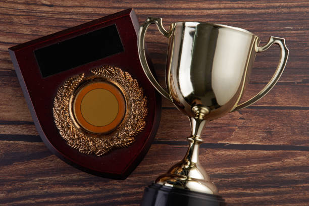 istock trophy and plaque on wood background 1254723767
