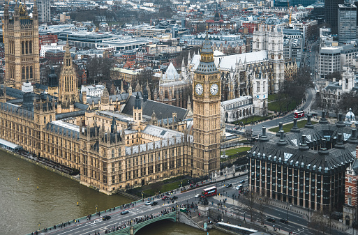 Famous Big Ben with bridge over Thames and tourboat on the river in London, England, UK