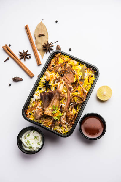 Online Food Delivery concept  - Gosht Pulao Or Mutton Biryani packed in Plastic box Restaurant style Gosht or Mutton Biryani or Pulao packed for home delivery in plastic box or container with Raita and salan masala stock pictures, royalty-free photos & images