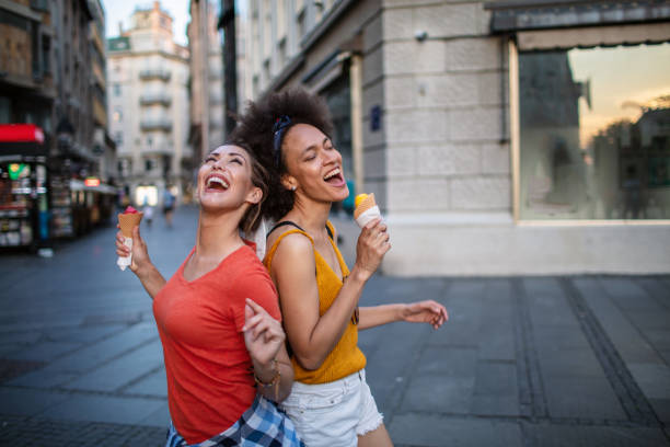 istock Female friends having fun and eating ice cream 1254725422