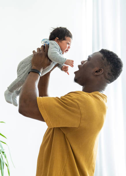 istock Playful father lifting newborn son 1254725569