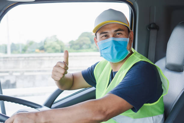 Professional truck driver to transport Professional worker, truck driver, middle-aged Asian man wearing protective mask And safety vests For a long transportation business semi truck photos stock pictures, royalty-free photos & images