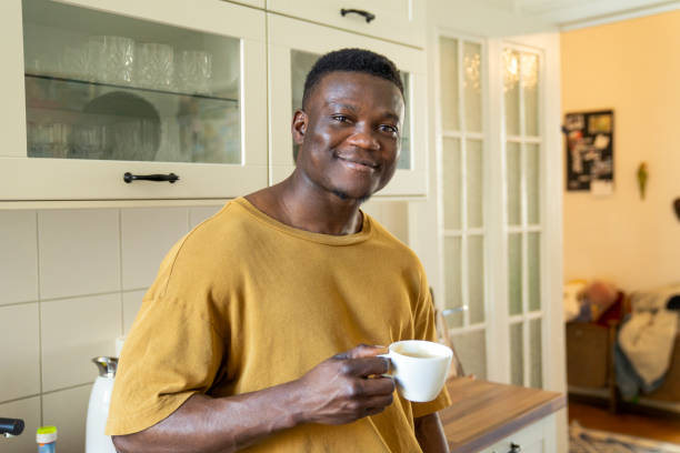 istock Smiling man drinking coffee in kitchen at home 1254727092