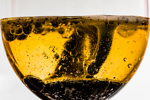 Glass cup with orange liquid and no with bubbles and ink