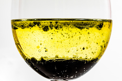 Glass cup with yellow liquid and no with bubbles and ink