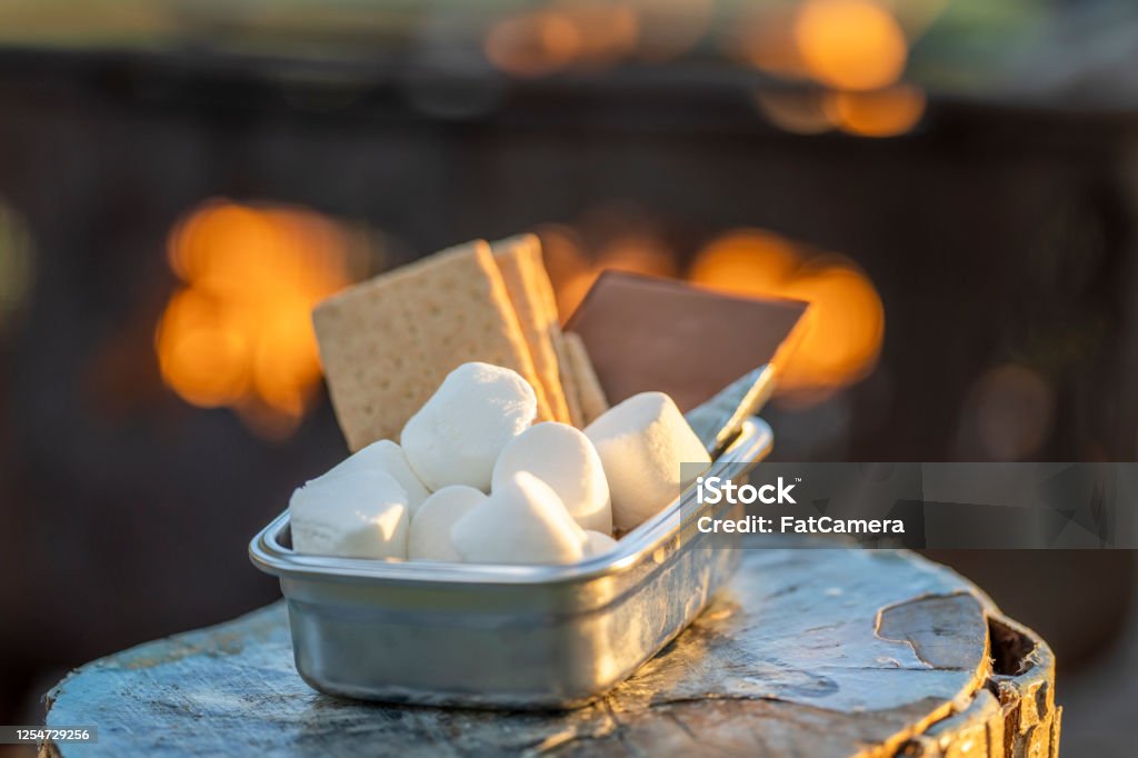 S'more kit Close-up of marshmallows, graham crackers, and chocolate (s'mores), around a campfire. Smore Stock Photo