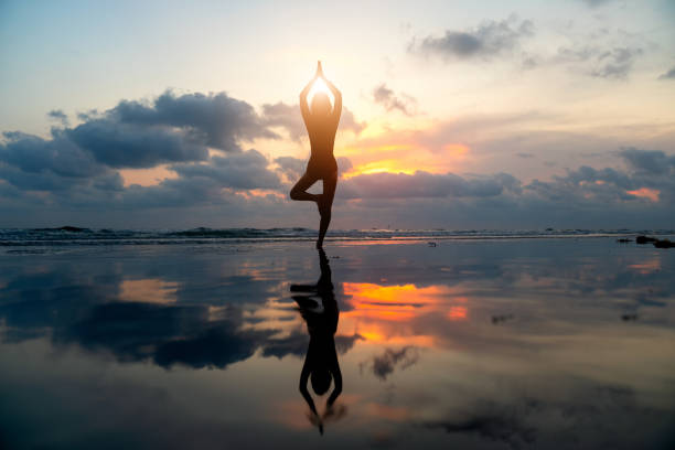 istock Silhouette young woman practicing yoga on the beach . 1254732637