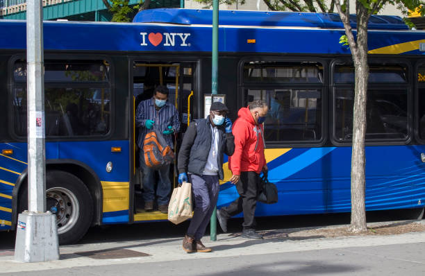 People leaving bus wearing masks during COVID-19 Bronx NY stock photo