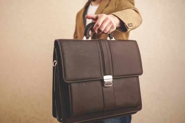 istock man in a jacket with a briefcase. the man holds out a briefcase 1254735177