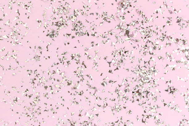 istock Silver glowing confetti scattered on a pastel purple background. 1254741453