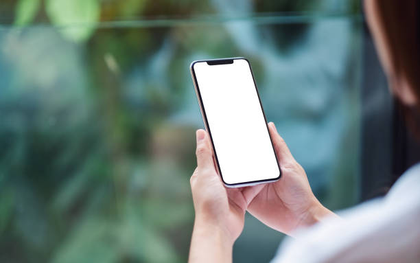 istock a woman holding mobile phone with blank white desktop screen , blurred green nature background 1254741678