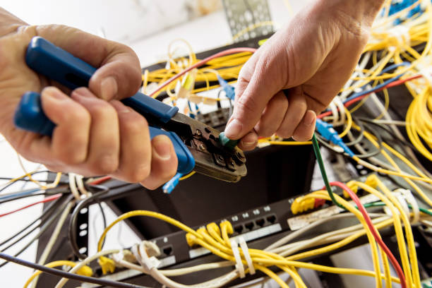 istock Network engineer working in server room. Connecting network cables to switches 1254741989