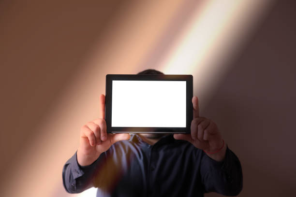 istock Man holding a tablet in hands. Screen instead of face. New technologies communication. 1254742773