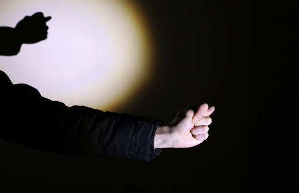 istock Man's hand in spotlight on black background. Fig sign. 1254742811