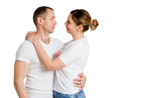 Portrait of a loving couple embracing. In light clothing. Isolated on white.