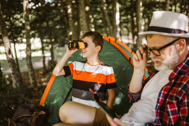 istock Boy camping with grandfather in the forest. 1254743034