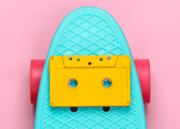 istock Cruiser board with audio cassette on a pink pastel background. 80s fun. Top view 1254747364