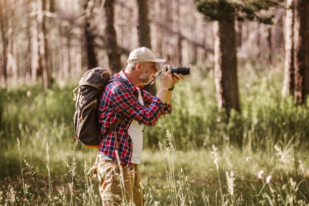 istock Male hiker photographing a nature with retro camera. 1254748196