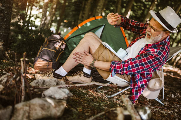istock Mosquito attack mature man in forest camping 1254750341