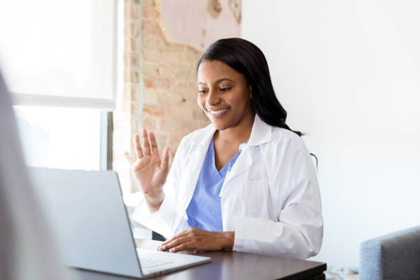 istock Female doctor waves at patient on video conference 1254753529