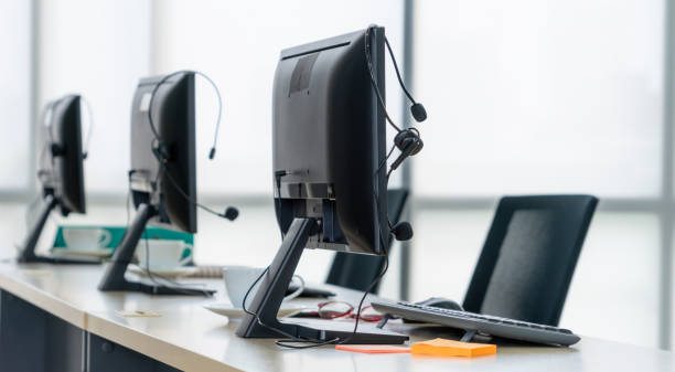 istock Call center computers and headsets all in office 1254753659