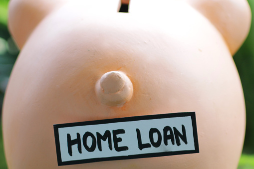 Stock photo showing a ceramic pig labelled with the words 'home loan'. This is a concept picture designed to suggest savings, mortgages, loans, home finances, wealth and the general cost of living.