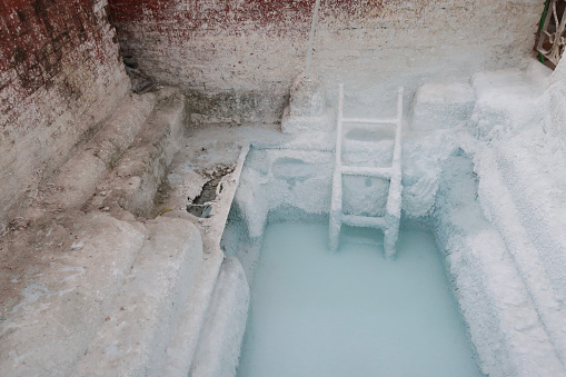 Stock photo showing storage tank for Boudhanath Stupa dome white painting solution, Kathmandu, Nepal. A Stupa (heap) is a mounded architectural structure for the storage of Buddhist monk or nun relics and used for meditation.