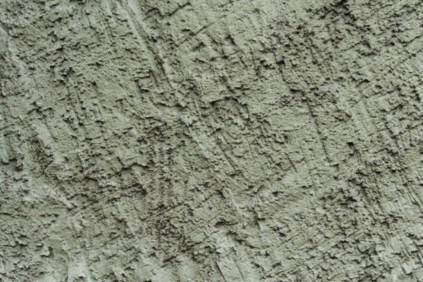istock Fragment of a roughly plastered exterior green wall. 1254754519