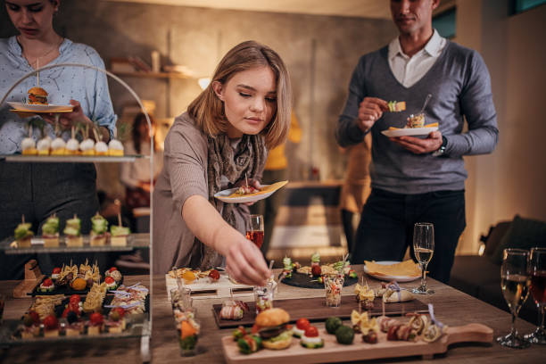 istock Business people sampling savory dishes from buffet table at office party 1254754720