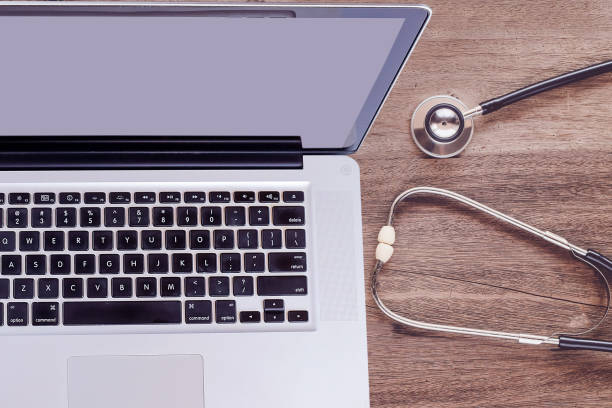 istock Top view laptop with stethoscope on old wood table. 1254756908
