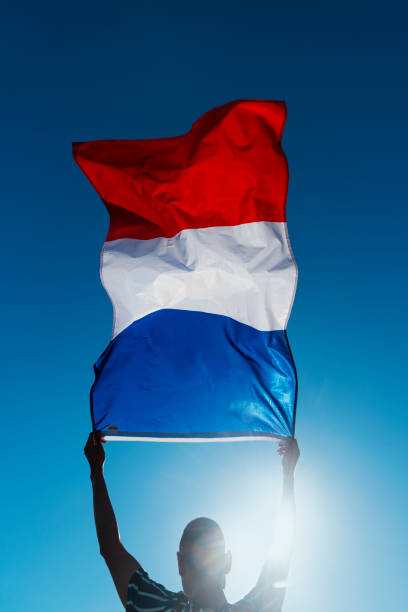 istock man waving a french flag on the wind 1254757589