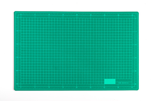 Green grid cutting matt or pad on background.