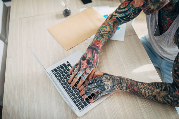istock Young tattooed man working from home 1254758159