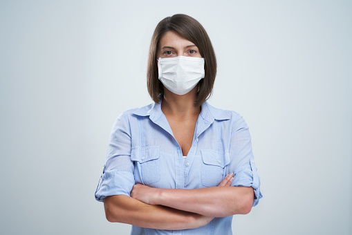 Picture of attractive woman wearing protective mask isolated over white background