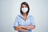 Attractive woman wearing protective mask isolated over white background