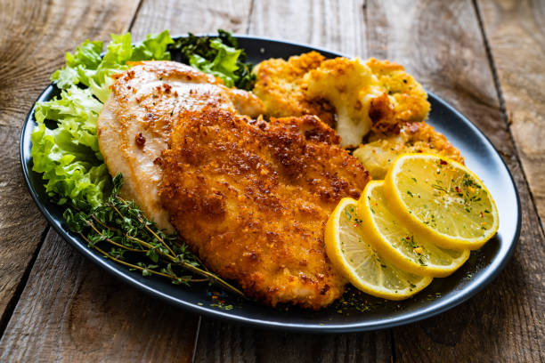 istock Fried pork chops and cauliflower on wooden table 1254759409