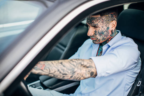 istock One young tattooed businessman driving a car 1254761339